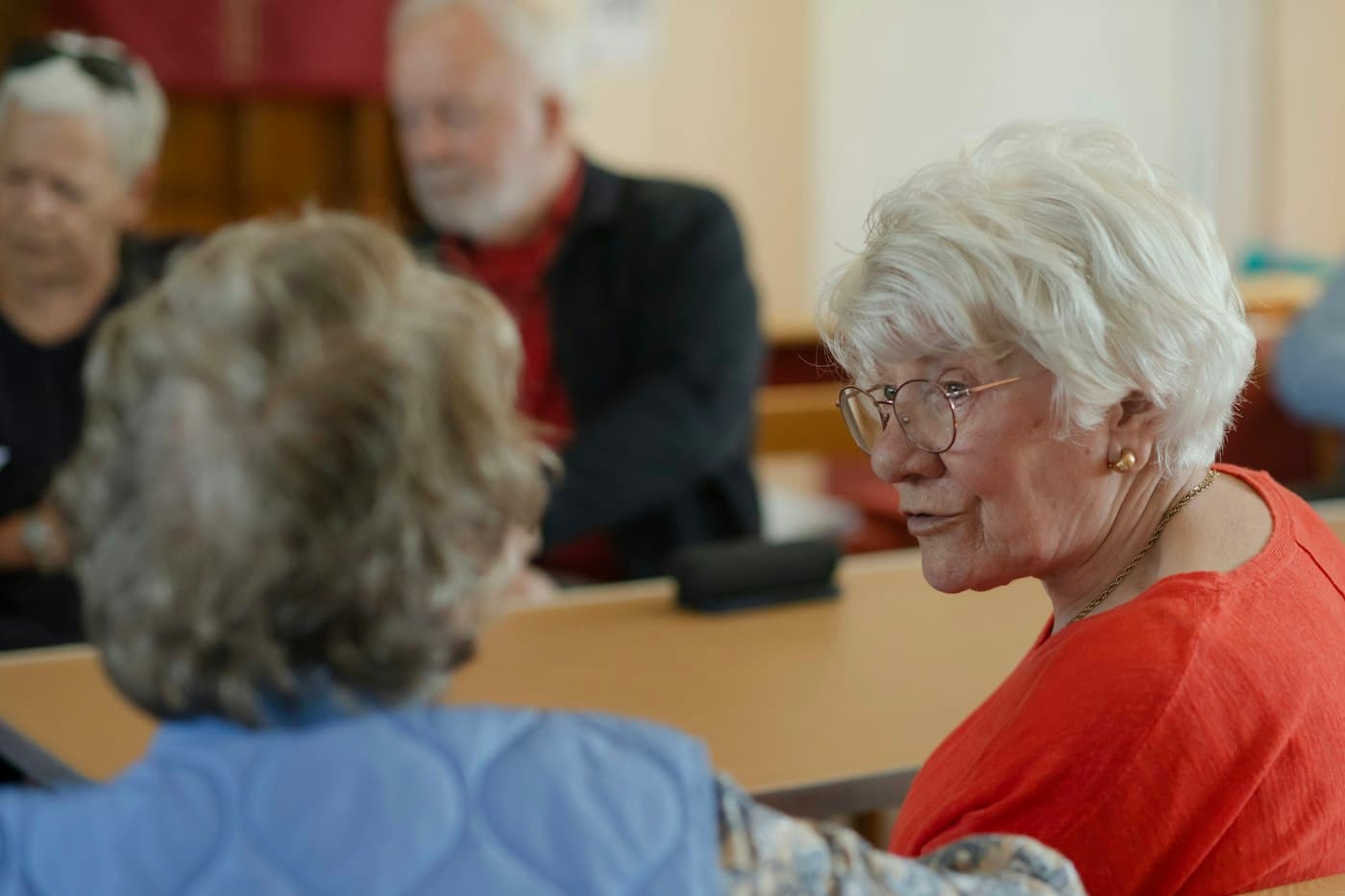 Dos mujeres mayores conversan alrededor de una mesa