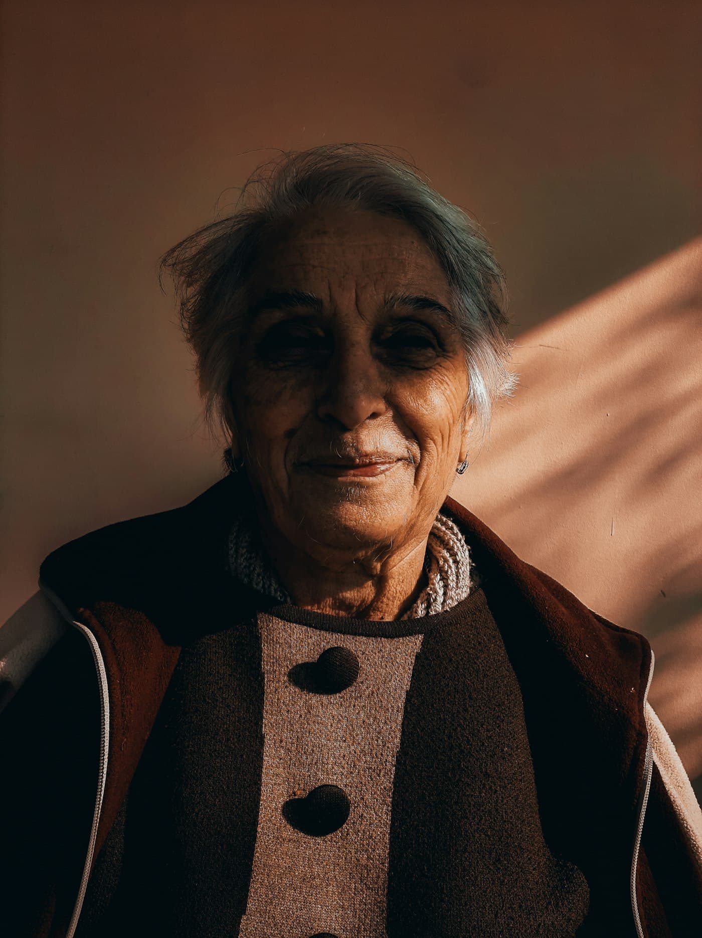 Retrato de una mujer mayor sonriendo con luz cálida